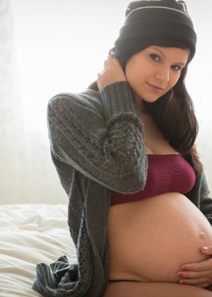 Сексуальная брюнетка с беременным животиком показывает себя с разных сторон, демонстрируя свою привлекательность